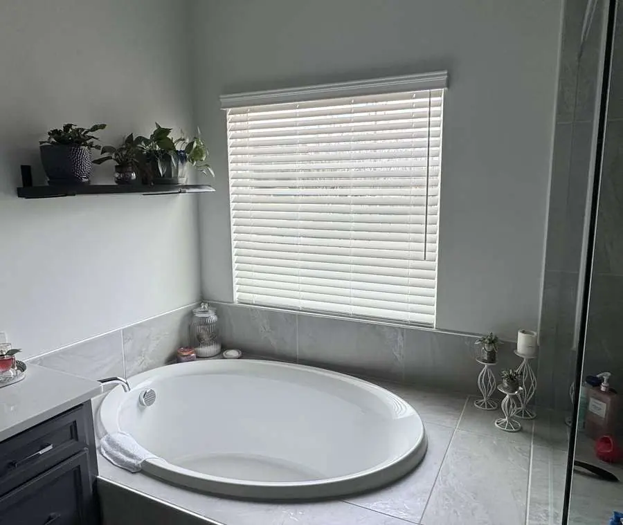 Faux wood blinds installed above a Carolina bathtub